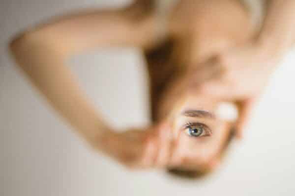 Retrato de una mujer profesional mirando a través de una ventana con el centro limpio y los bordes empañados, ajustando sus gafas. Texto: 'TU AUTOCONCIENCIA ES EL TECHO DE TU LIDERAZGO'. Metáfora de liderazgo consciente y autoconocimiento de OAZ.